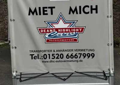 Rückansicht eines Agados Anhängers mit Mietinformationen und QR-Code.
