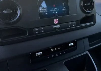 Armaturenbrett mit Navigationssystem und Bedienelementen in einem Sprinter Fahrzeug.