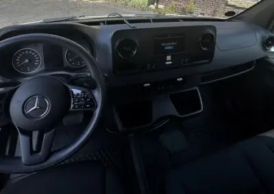Innenansicht eines Mercedes Sprinter mit Lenkrad und Armaturenbrett.
