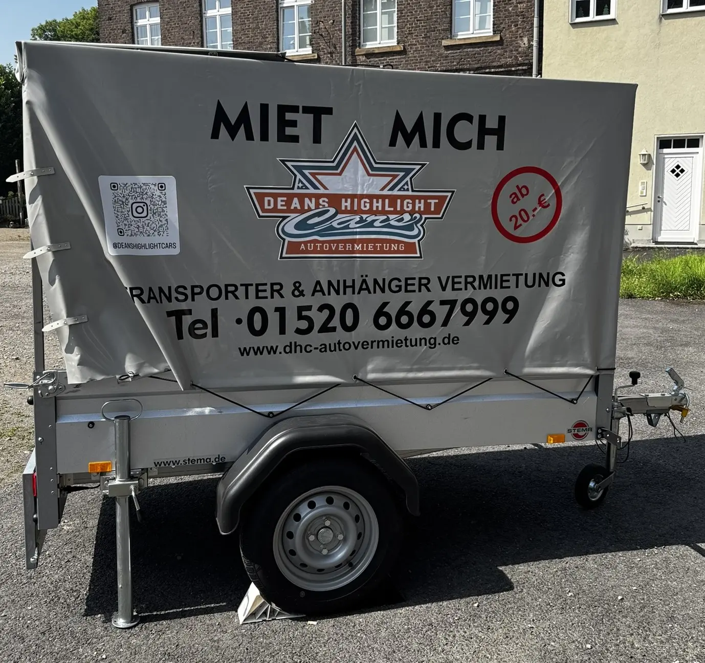 Ein Anhänger mit einem grauen Verdeck und einem Mietangebot von Deans Highlight Cars.