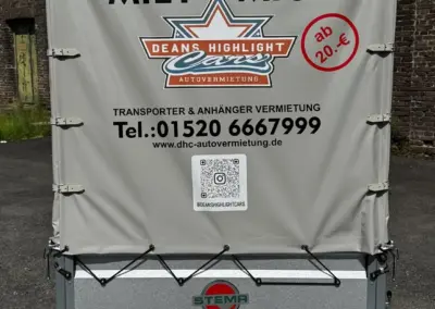 Rückansicht eines Transporters mit einem Mietangebot und Kontaktdaten von Deans Highlight Cars.