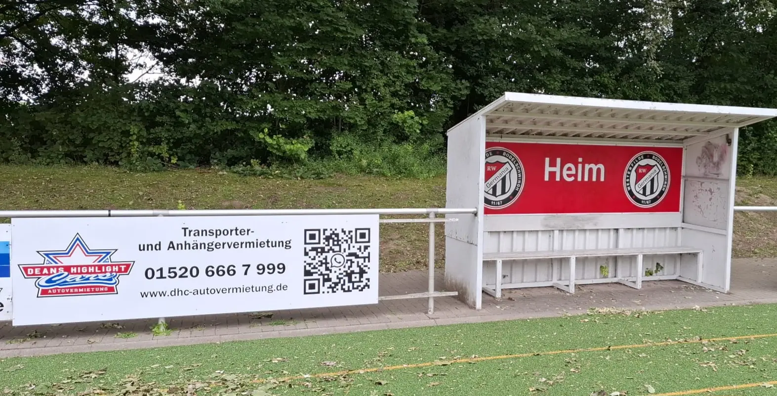 Sitzbank mit dem Wort 'Heim' und Werbung für Transporter- und Anhängermietung.